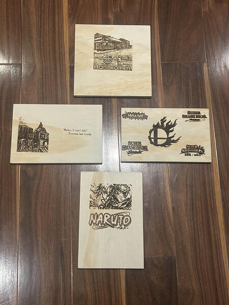 Four laser-engraved wooden boards featuring detailed artwork